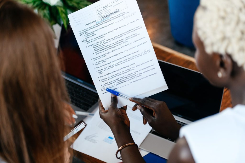 Membres de l'équipe examinant et discutant d'un document dans un cadre de bureau professionnel.