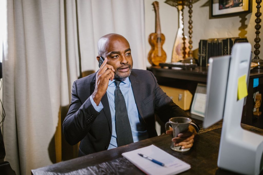 Professionnel des affaires dans un bureau à domicile au téléphone, travaillant à distance.