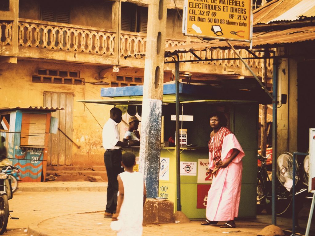Scène dynamique de marché de rue représentant la vie africaine locale à un stand extérieur.
