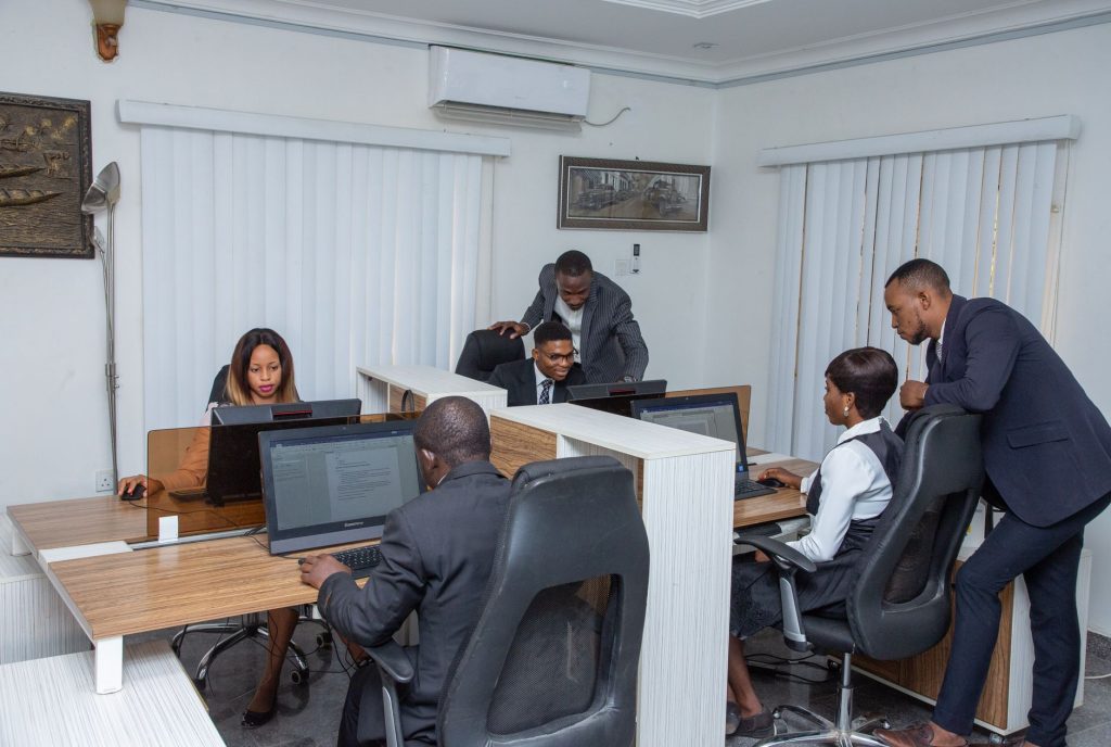Un groupe de professionnels travaillant ensemble dans un bureau moderne, mettant en avant le travail d'équipe et la productivité.